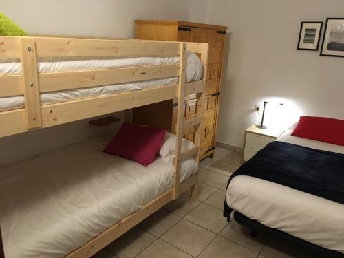 Un dormitorio con dos literas y una cama. en Enjoy Apartment, en Pas de la Casa