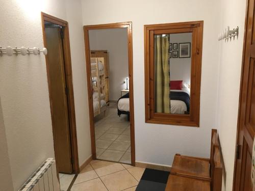 un pasillo con espejo y un dormitorio en Enjoy Apartment, en Pas de la Casa