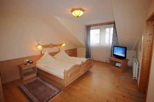 a bedroom with a large bed and a television at Parkhotel Emstaler Höhe in Bad Emstal