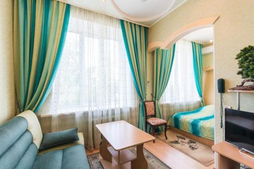 a living room with a couch and a bed and a television at Profsoyuznaya Hotel in Nizhny Novgorod