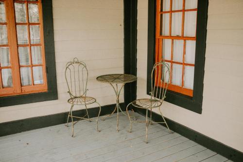 two chairs and a table sitting on a porch at Maison Mouton Bed & Breakfast in Lafayette