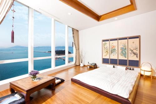 a bedroom with a bed and large windows at Sono Calm Yeosu in Yeosu