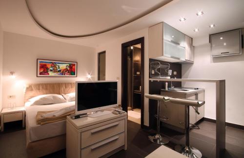 a bedroom with a bed and a flat screen tv at Apartments and Rooms Teona in Budva