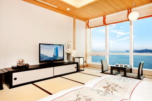 a living room with a large window overlooking the ocean at Sono Calm Yeosu in Yeosu