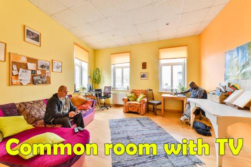 a living room with two women sitting on a couch at Central Hostel in Riga