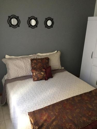 a bedroom with a bed with three mirrors on the wall at Apartamento Cantinho da Serra in Nova Friburgo