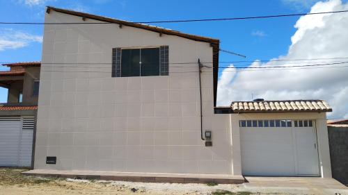 a white building with two garage doors in front at Pousada Don'Ana in Conde