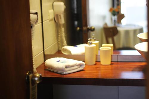 a bathroom with a counter with towels and a mirror at Hotel D&V Concepción in Concepción