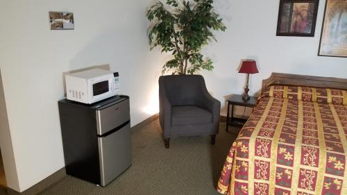 a hotel room with a bed and a microwave on a dresser at Amber Inn Motel in Bliss