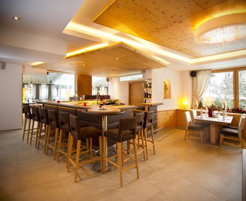 a large kitchen with a bar with stools at Hotel Alpina in Rauris
