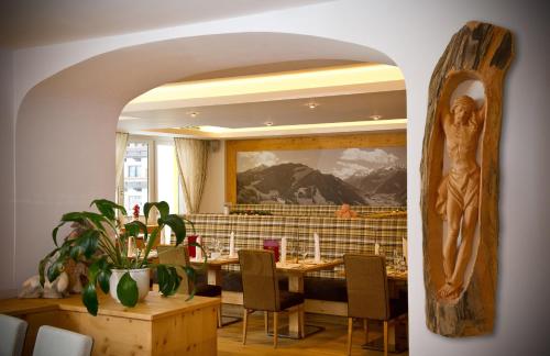 a dining room with a table and a statue on the wall at Hotel Alpina in Rauris