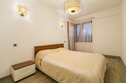 a small bedroom with a bed and a window at Loft Apartment Silver Mountain in Poiana Brasov