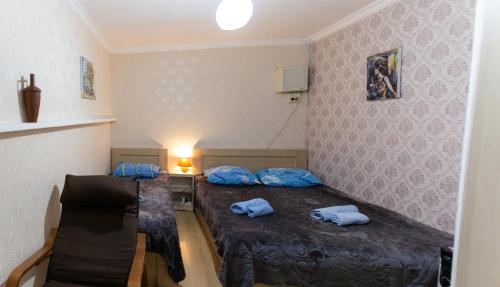 a small room with two beds and a table at Guest House Hello in Tbilisi City