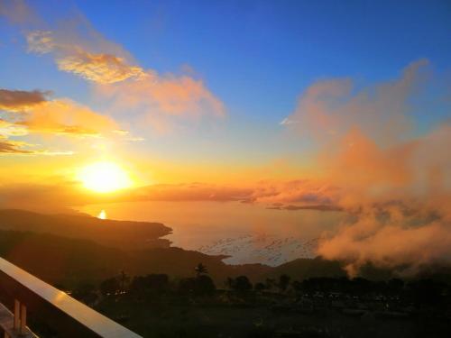 - un coucher de soleil sur l'océan et le ciel dans l'établissement Breezy Tagaytay Condo, à Tagaytay