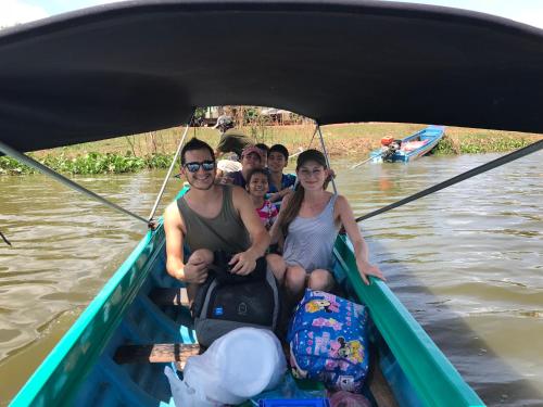 a group of people sitting in a boat on the water at Madam Sokha Homesteading in Siem Reap