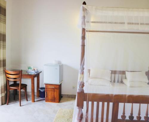 a bedroom with a bed and a desk and a table at Supun Villa in Bentota