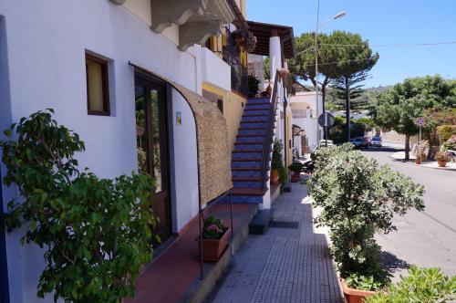 a building with blue stairs and a sidewalk with plants at Casa Matarazzo in Lipari