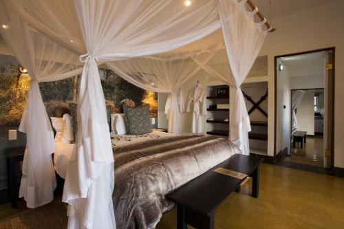a bedroom with a large bed with a canopy at isiLimela Game Lodge in Hoedspruit