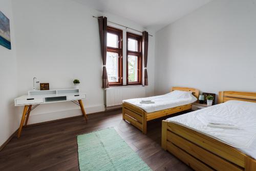 ジェールにあるGold Apartment - Győrのベッドルーム1室(ベッド2台、デスク、窓付)