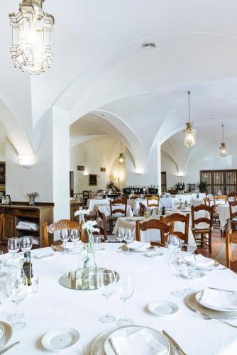 a dining room with white tables and chairs at Parador de Mérida in Merida