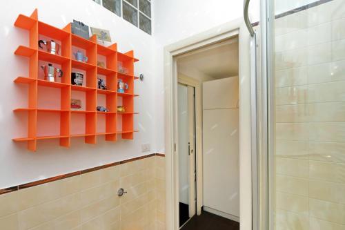 ローマにあるMok'house Apartmentsのバスルーム(壁にオレンジの棚付)