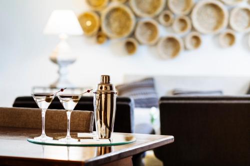 a table with two glasses and a bottle on it at Parador de Mérida in Merida