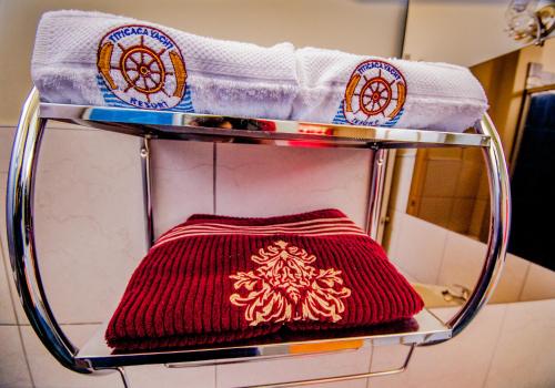 a shelf with towels and a red and white towel at Yacht Lago Titicaca in Ichu