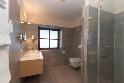 a bathroom with a shower and a sink and a toilet at Alpenresidenz Buchenhöhe in Berchtesgaden