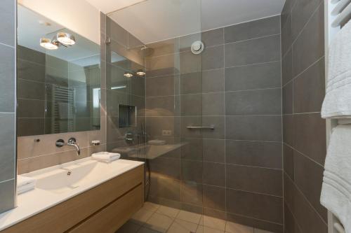 a bathroom with a sink and a mirror at Alpenresidenz Buchenhöhe in Berchtesgaden