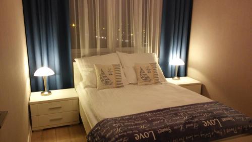 sypialnia z łóżkiem z poduszkami i 2 lampami w obiekcie PANORAMA KOSZALIN w Koszalinie