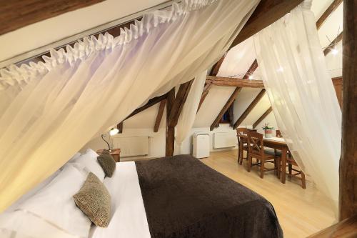 - une chambre avec un lit et une table avec des chaises dans l'établissement Castle View Apartments, à Český Krumlov