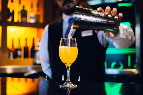 a man is pouring a glass of beer at voco Letchworth Hall by IHG in Letchworth