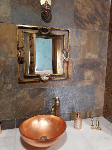 a bathroom with a copper sink and a mirror at Riad Medina Mudejar in Toledo