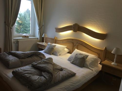 a bedroom with a bed with two pillows on it at Maison La Devinière - sauna et spa compris accessibles toute l'année in Xonrupt-Longemer