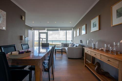 ein Wohnzimmer mit einem Tisch und einem Sofa in der Unterkunft Panoramic & Modern apartment with sea view in Bredene
