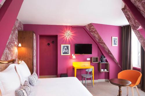 um quarto com paredes roxas, uma cama e uma secretária em Hôtel Joséphine by Happyculture em Paris