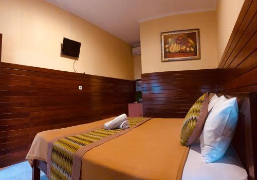 a hotel room with two beds and a tv at Taman Homestay in Nusa Lembongan