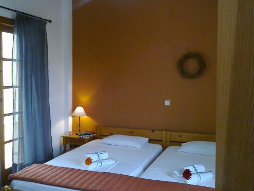 two twin beds in a room with a window at Sofia Apartments - Kantia in Kandia