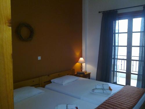 a bedroom with two beds and a window at Sofia Apartments - Kantia in Kandia