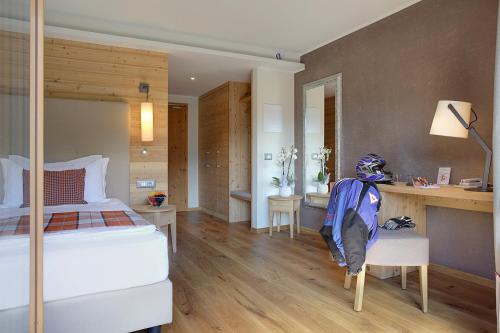 a bedroom with a bed and a desk in it at Active Hotel Monte Giner in Mezzana