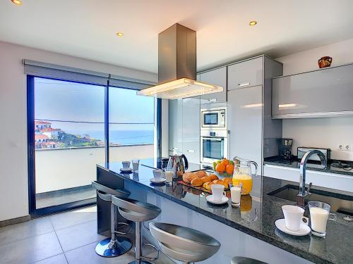 a kitchen with a counter with a view of the ocean at Villa North Sea by LovelyStay in Ponta Delgada