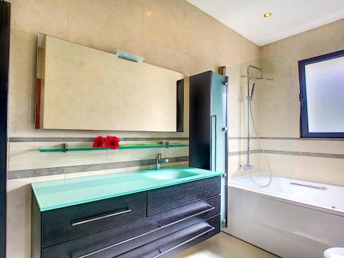 a bathroom with a sink and a mirror and a tub at Villa North Sea by LovelyStay in Ponta Delgada