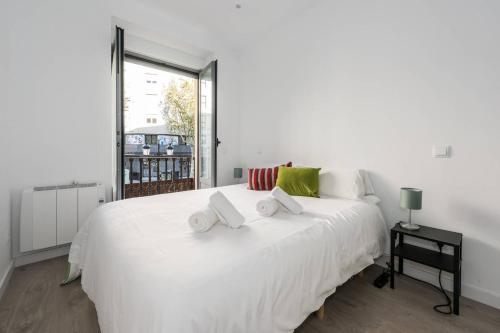 a white bed in a room with a window at Modern With Ideal Location Next To Atocha Station in Madrid