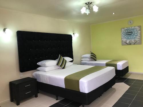 a bedroom with two beds and a headboard at Moatoga Hotel in Apia