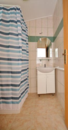 a bathroom with a sink and a mirror at Apartmani Cesarec in Vrboska