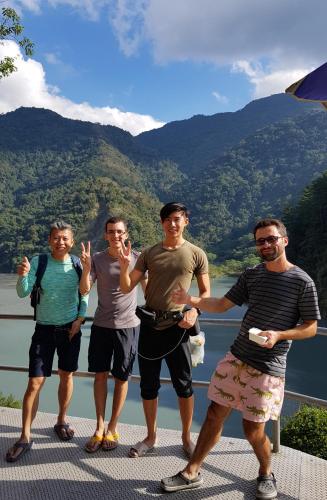 a group of men standing in front of a lake at MILU Backpacker Hostel in Puli