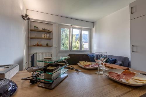 uma sala de estar com uma mesa com comida e copos de vinho em Portes de la vieille ville em Annecy