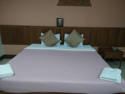 a large white bed with two pillows on it at Butnamtong Hotel in Lampang