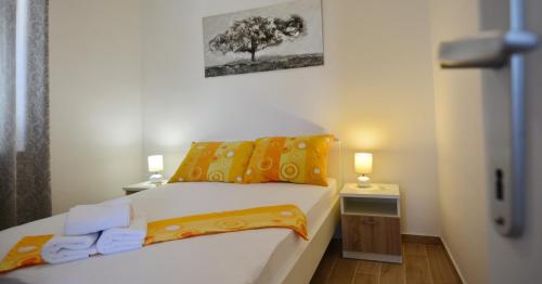 ein kleines Schlafzimmer mit einem Bett und einem Baum an der Wand in der Unterkunft Apartmani Cesarec in Basina