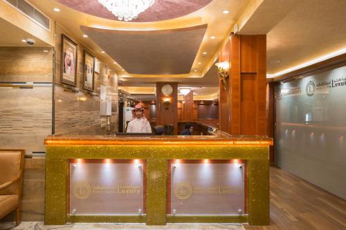 una mujer parada detrás de un bar en un restaurante en Luxury hotel apartments, en Tabuk